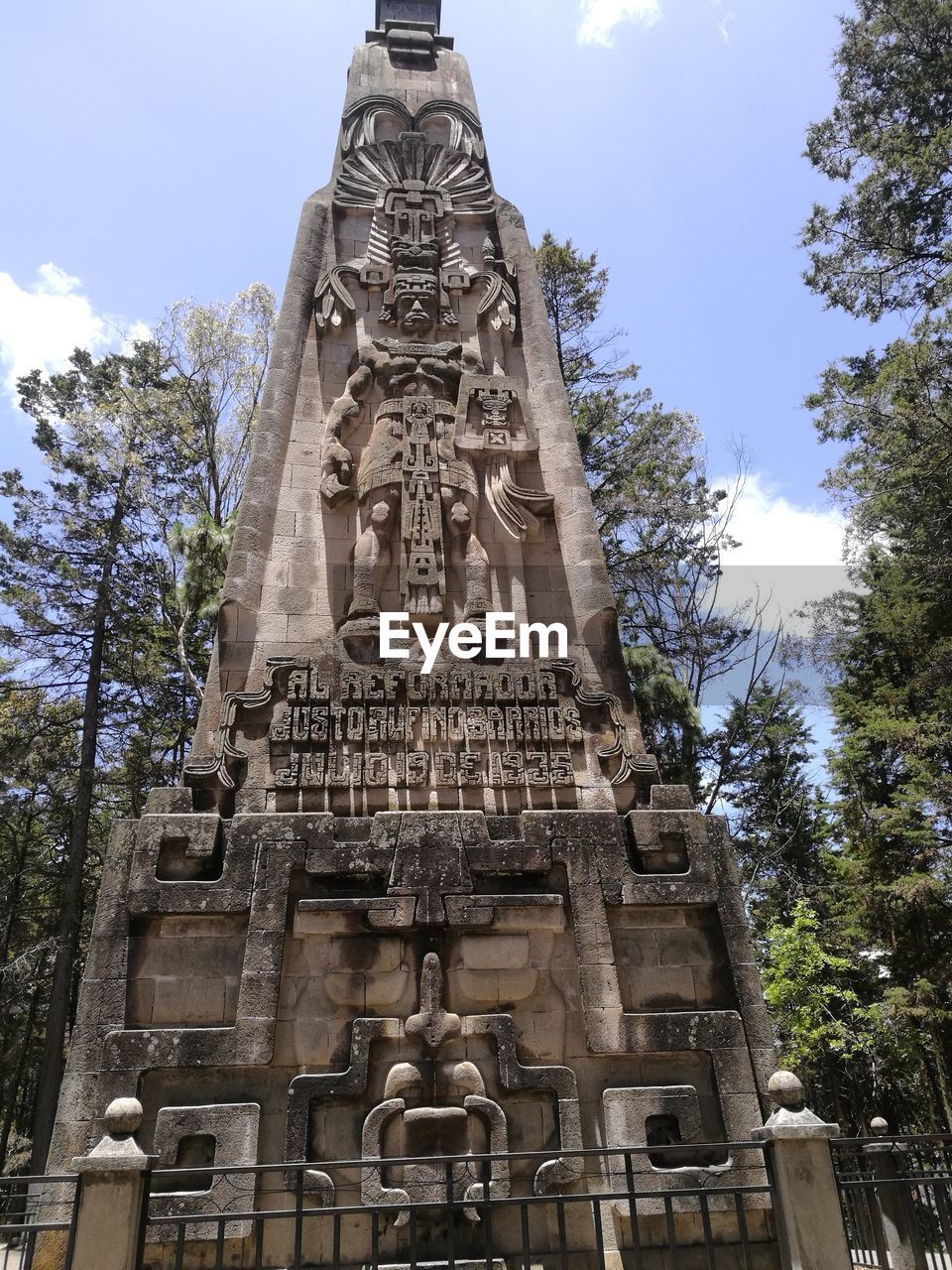 LOW ANGLE VIEW OF SCULPTURE AGAINST TREES