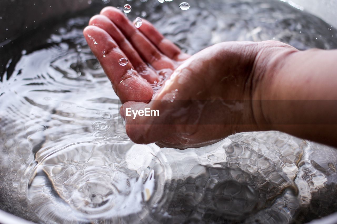 Cropped image of man splashing water