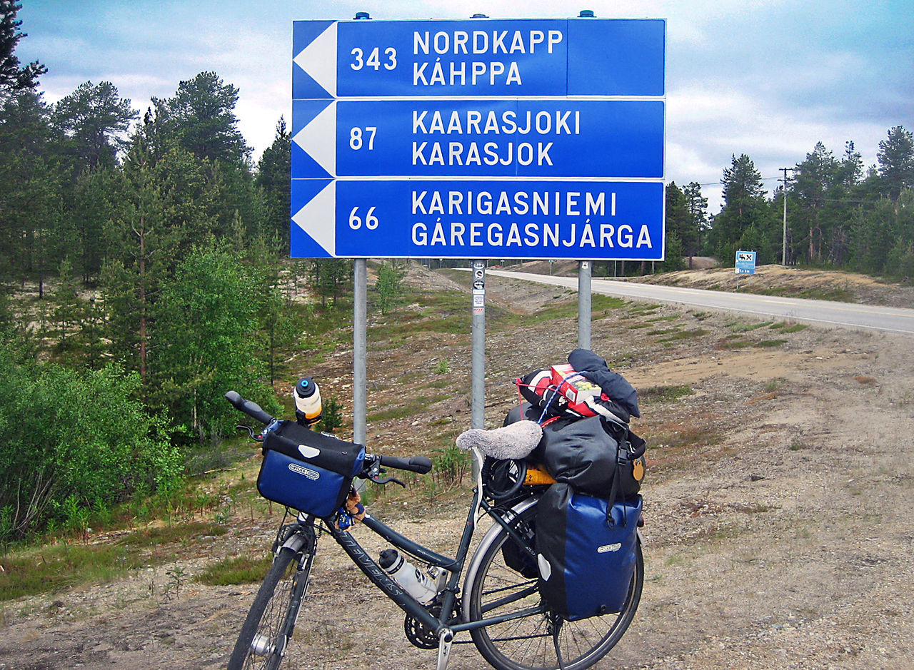 Bicycle parked against information sign