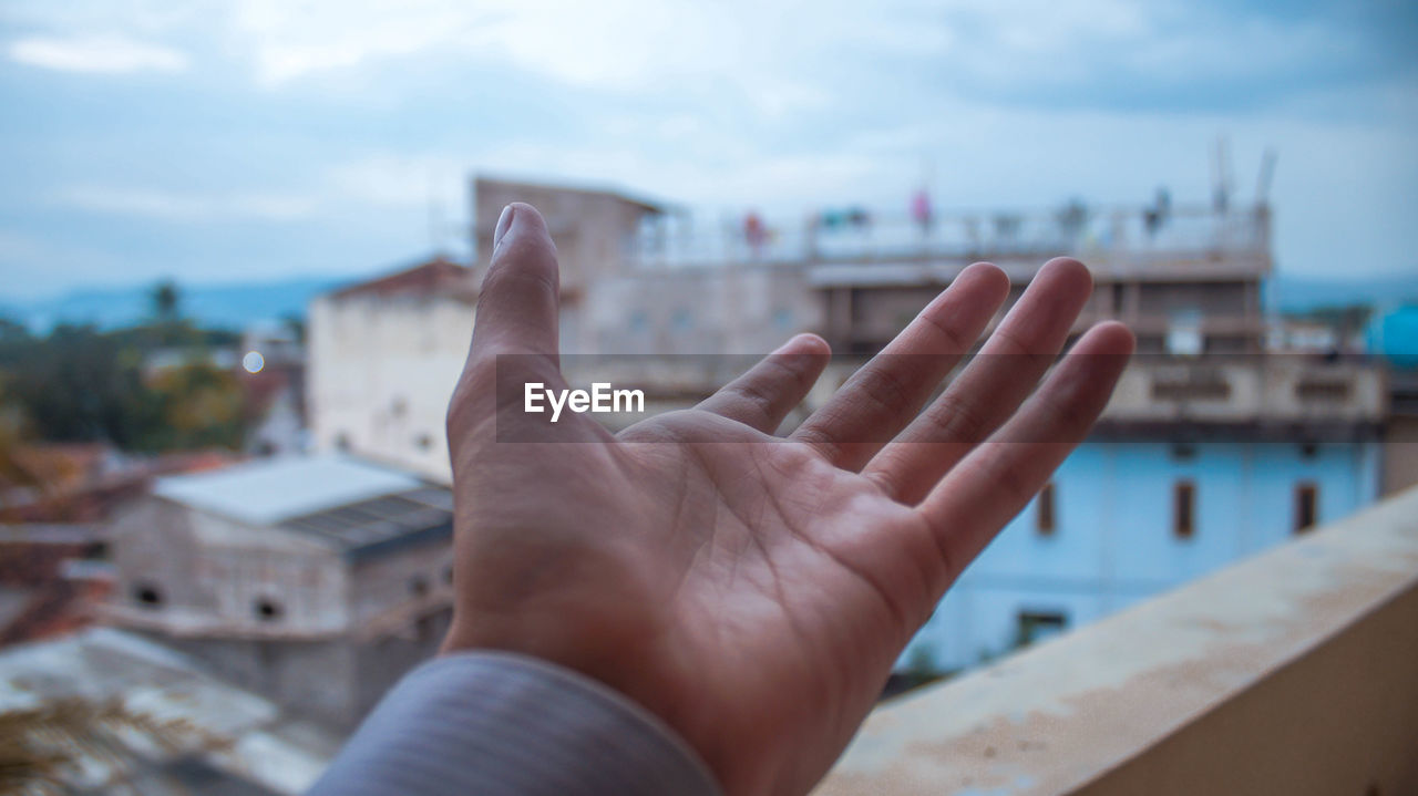 MIDSECTION OF PERSON WITH CITYSCAPE IN BACKGROUND