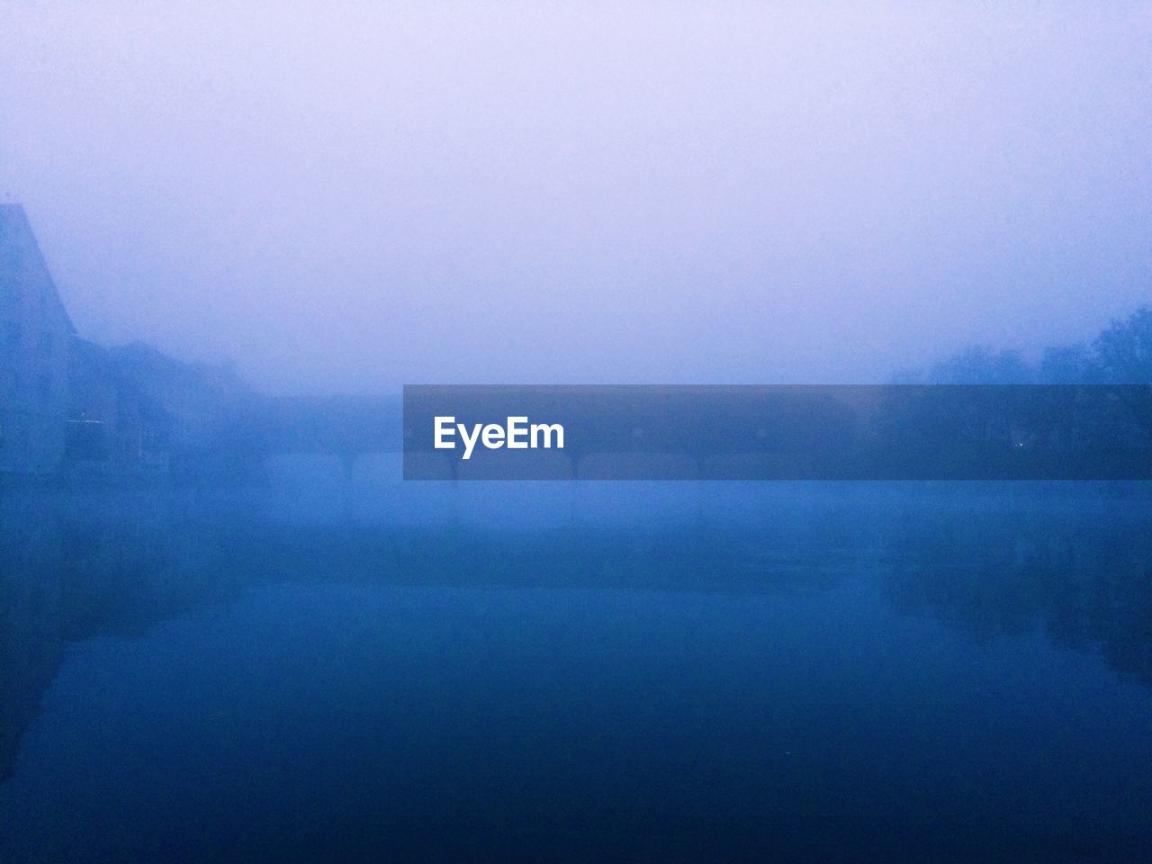 Scenic view of lake in foggy weather