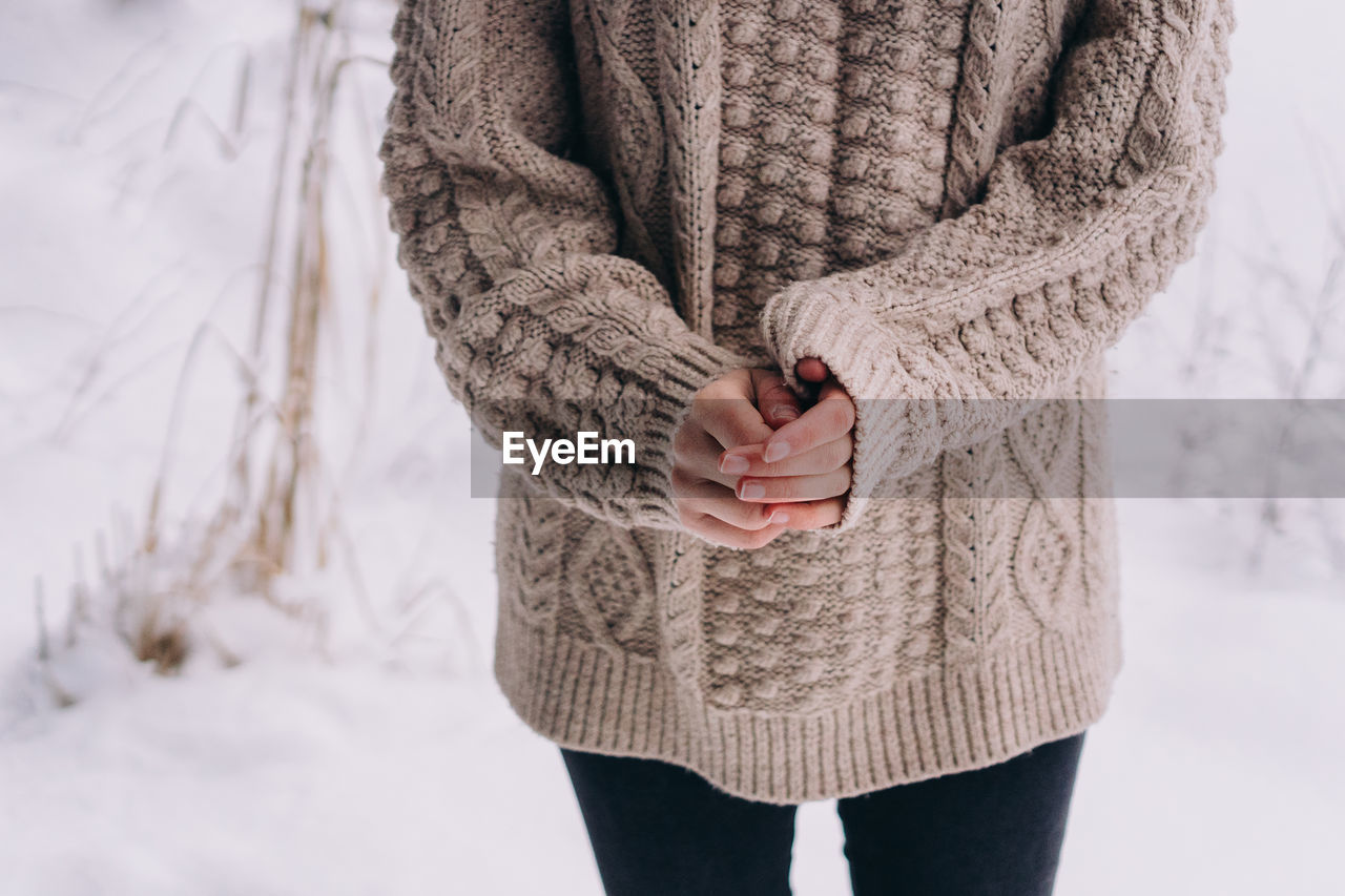 Midsection of woman standing in snow