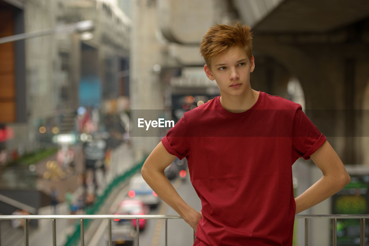 PORTRAIT OF TEENAGE BOY STANDING IN OFFICE