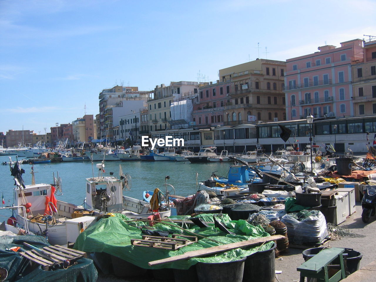 Boats moored at harbor against sky