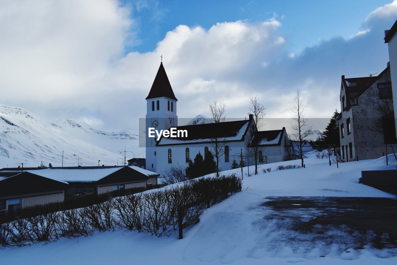 Low angle view of church against cloudy sky during winter