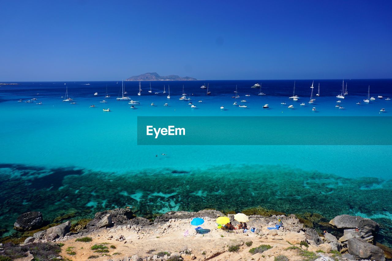 Scenic view of beach against clear blue sky