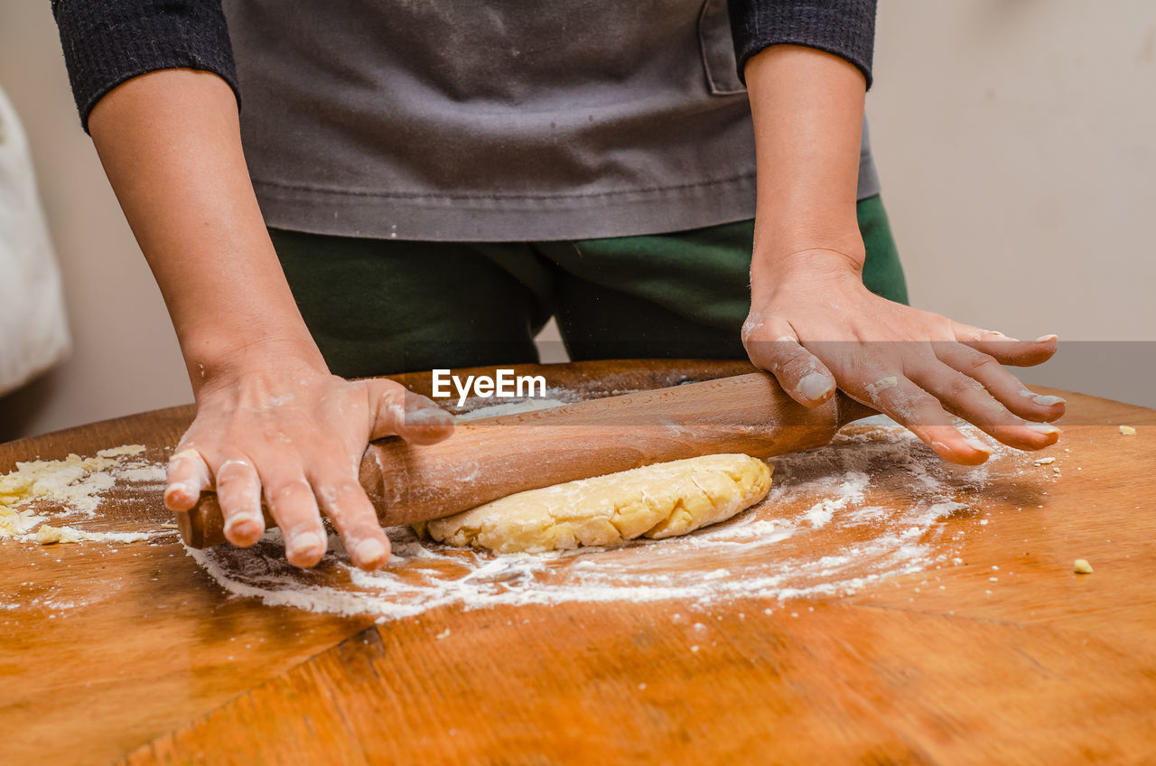 Rolling out cookie dough with wooden splinter on the table