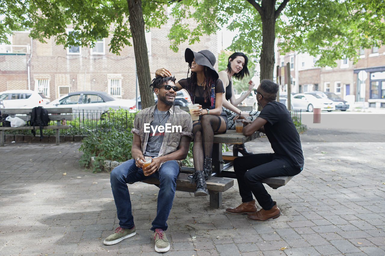 Four young adults sitting on a picnic table.