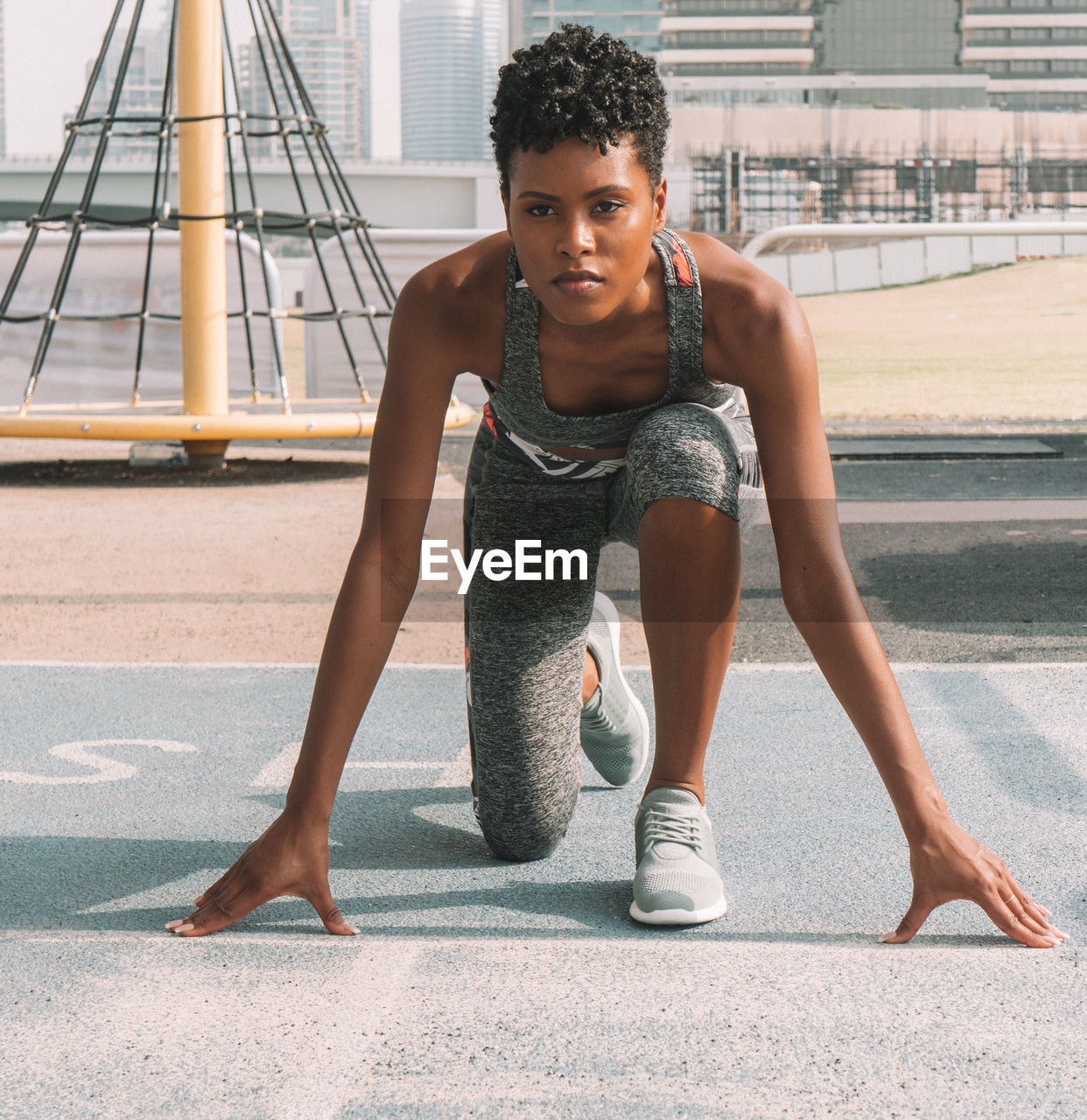 Portrait of woman preparing for race on road