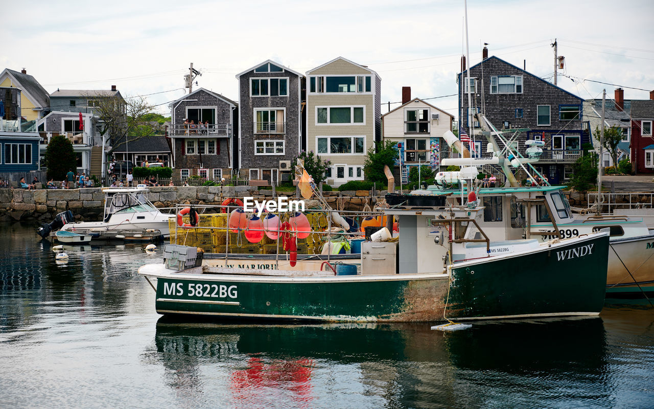 BOATS MOORED AT HARBOR BY BUILDINGS