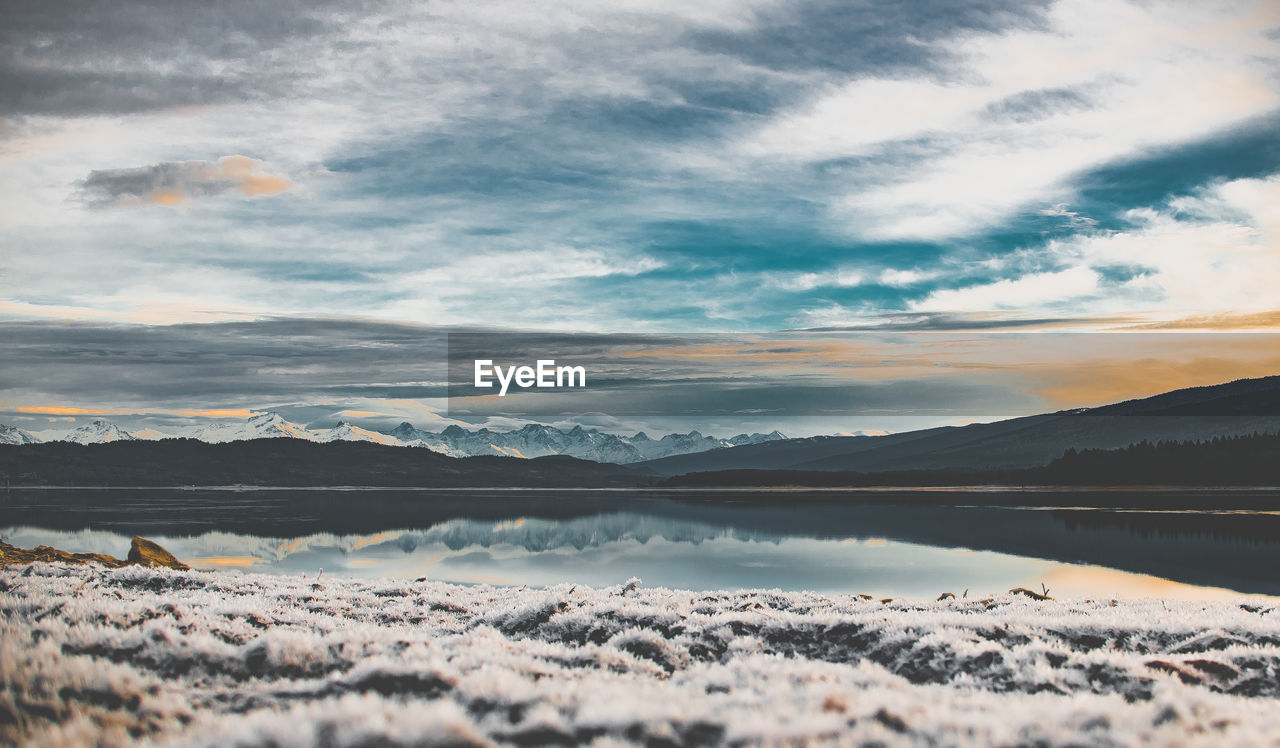 SCENIC VIEW OF LAKE AGAINST CLOUDY SKY