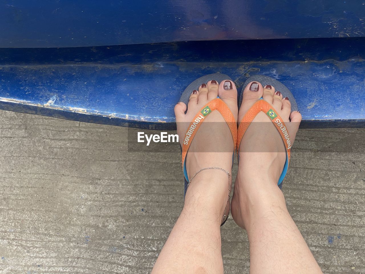 LOW SECTION OF WOMAN IN SWIMMING POOL AGAINST SEA