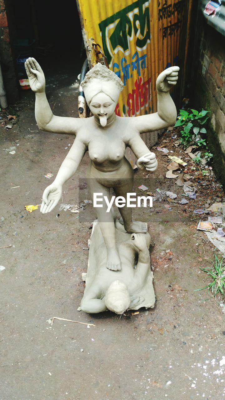 CLOSE-UP OF BUDDHA STATUE OUTDOORS