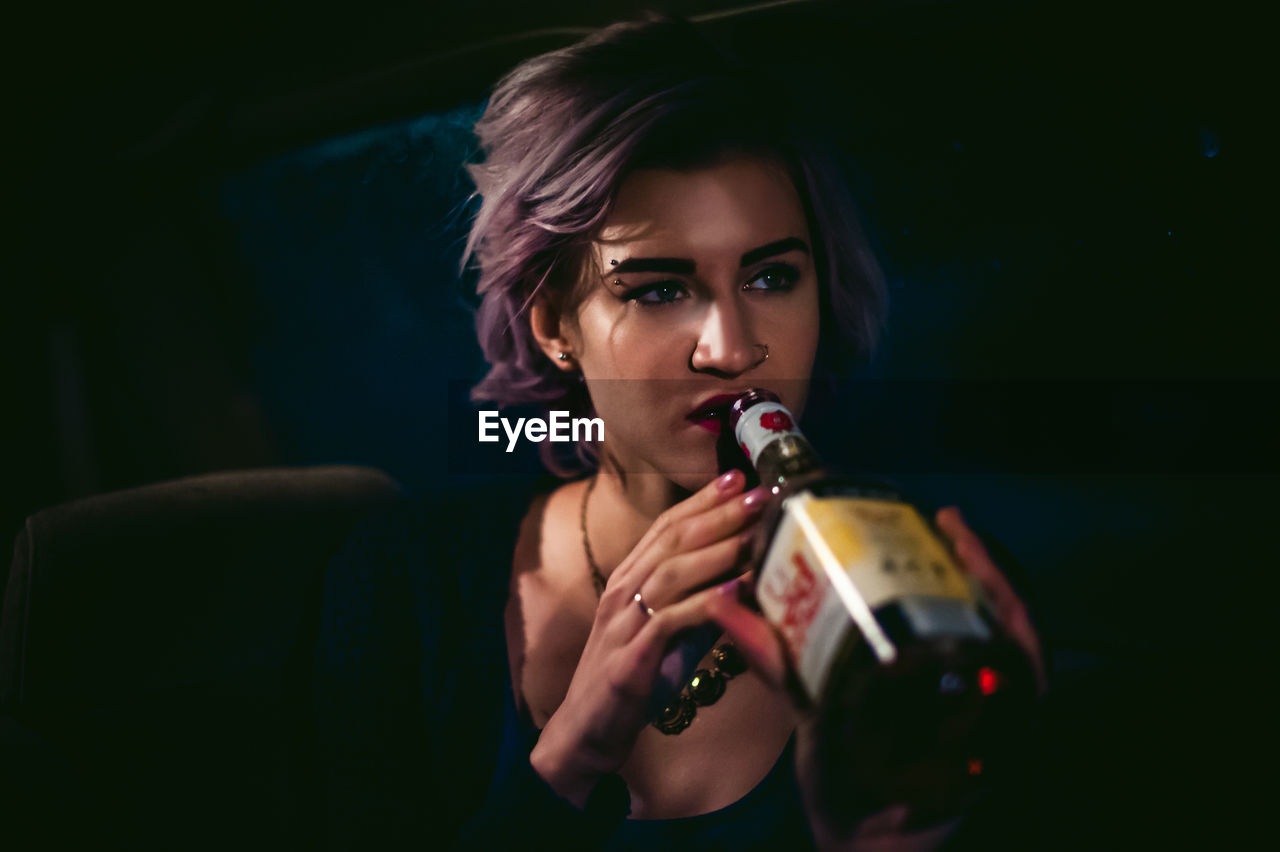 Close-up of woman drinking drink from bottle