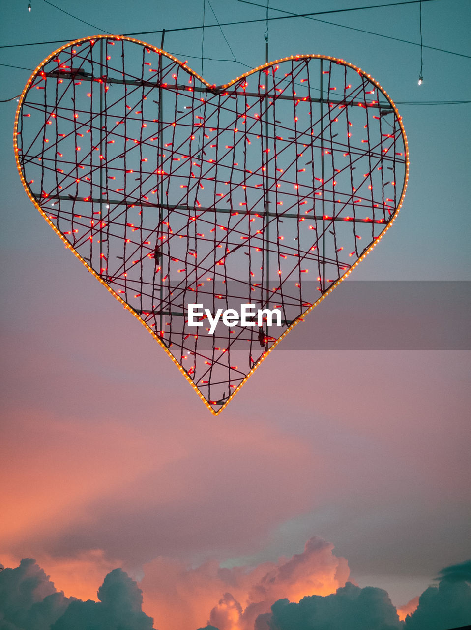 Low angle view of heart shaped illumination against sky during sunset