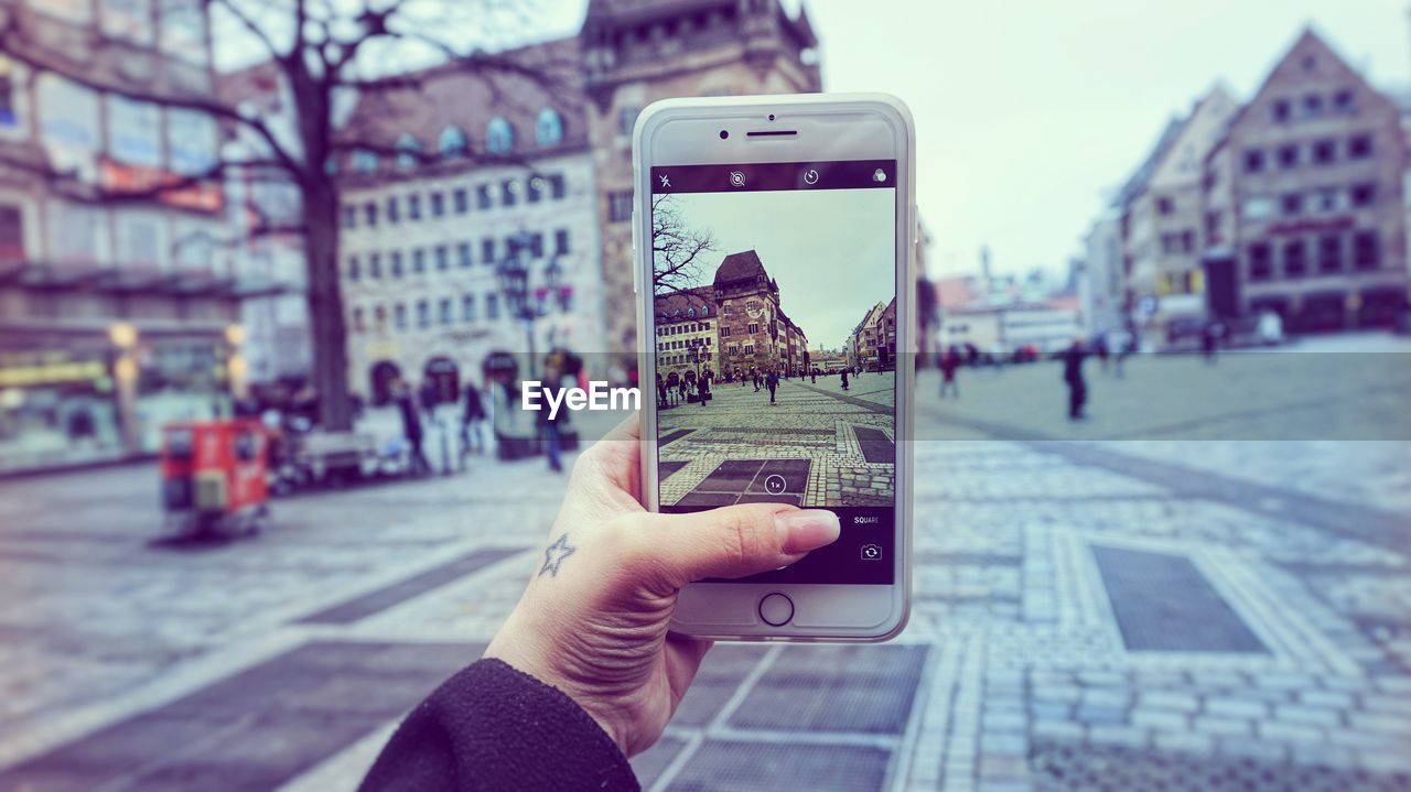 CLOSE-UP OF MAN PHOTOGRAPHING WITH MOBILE PHONE