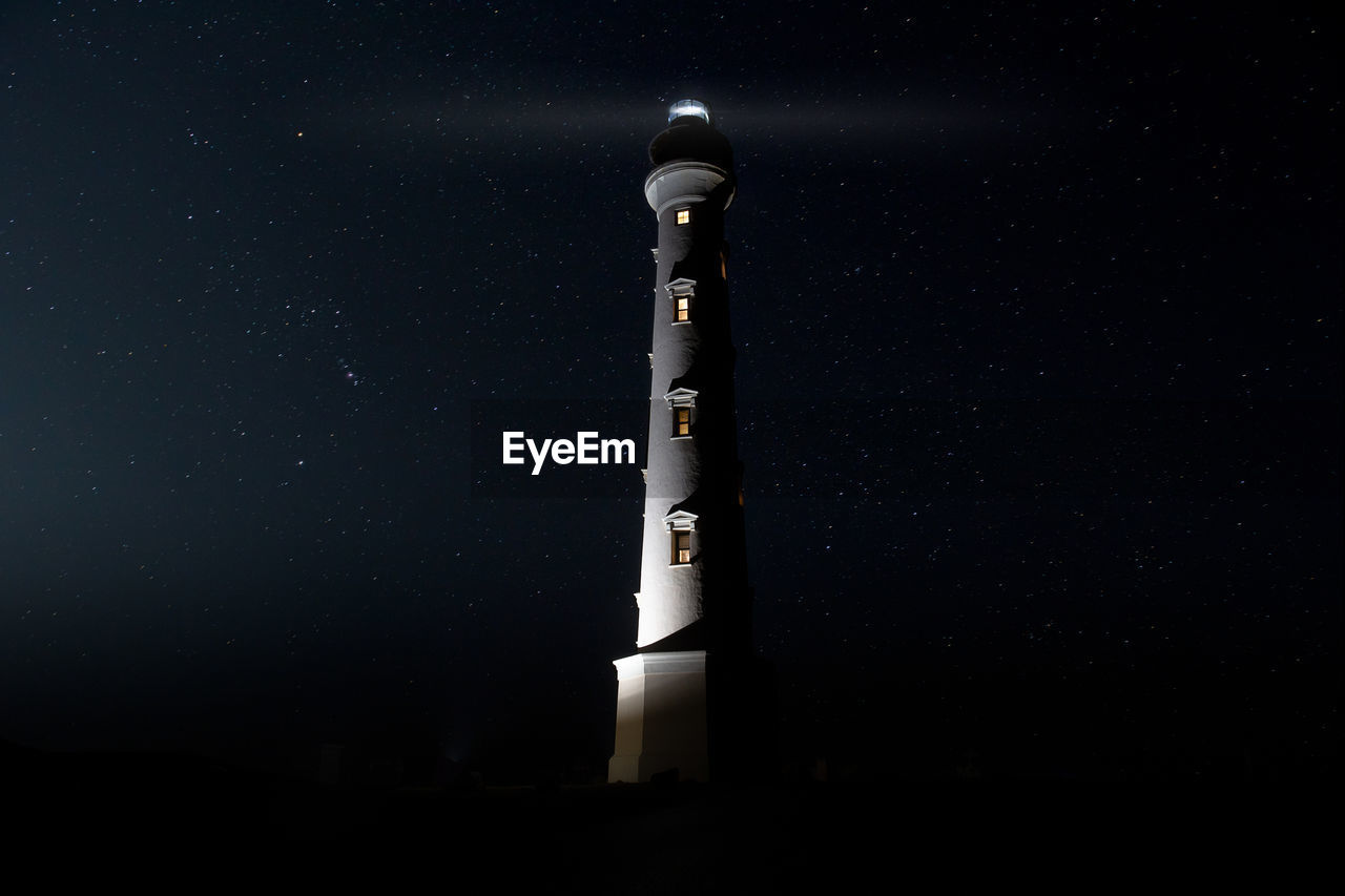 Low angle view of illuminated tower against sky at night