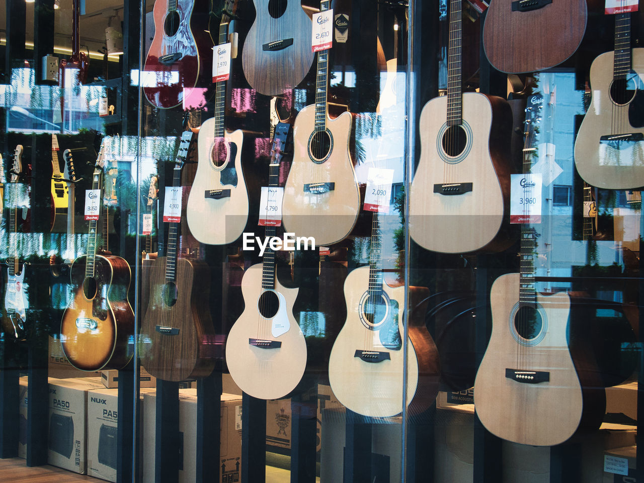 string instrument, guitar, musical instrument, music, musical equipment, arts culture and entertainment, variation, retail, acoustic guitar, hanging, plucked string instruments, store, electric guitar, no people, string, large group of objects, musical instrument string, indoors, abundance