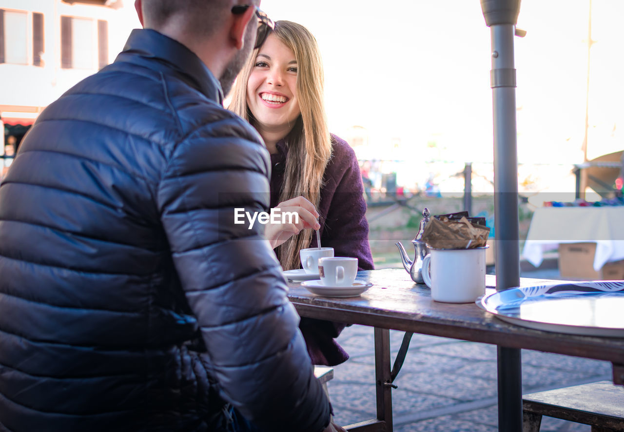 YOUNG WOMAN SITTING WITH COFFEE