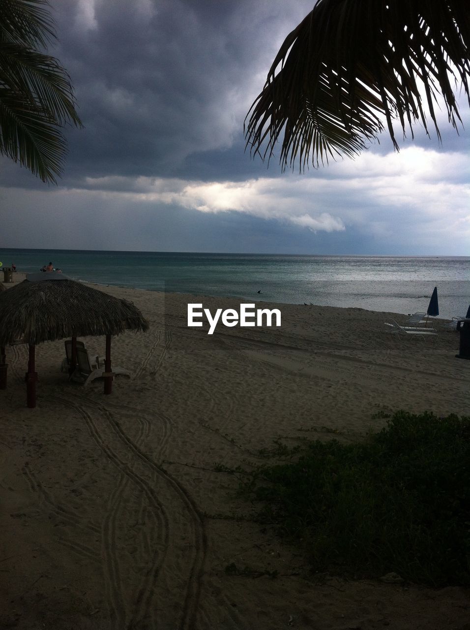 VIEW OF BEACH AGAINST CLOUDY SKY