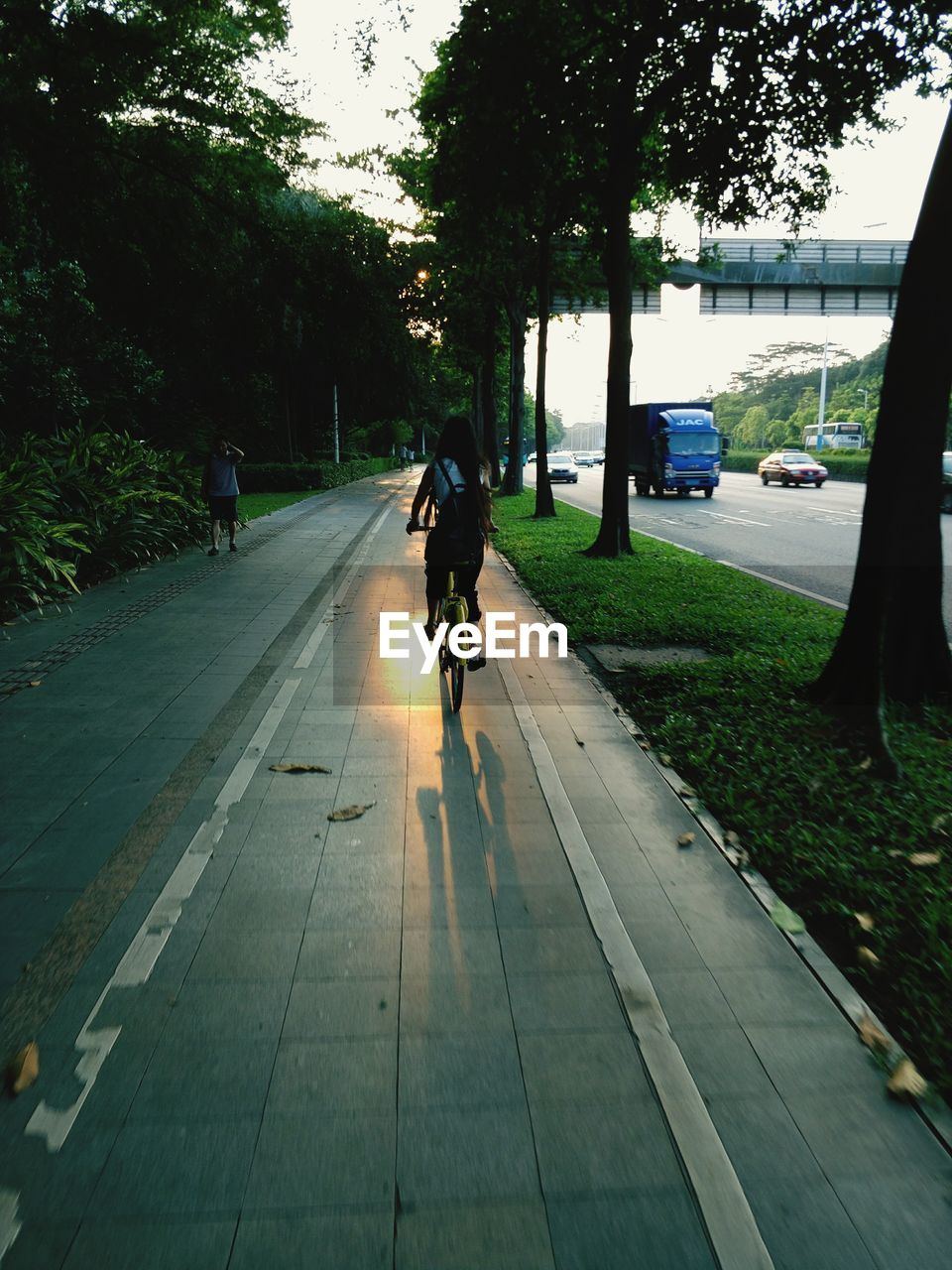 REAR VIEW OF WOMAN WALKING ON STREET