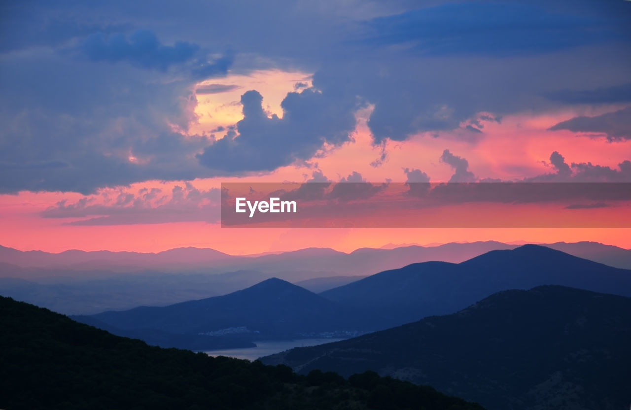 Scenic landscape of mountain ridges and sun rays reflecting in the lake waters at the golden hour