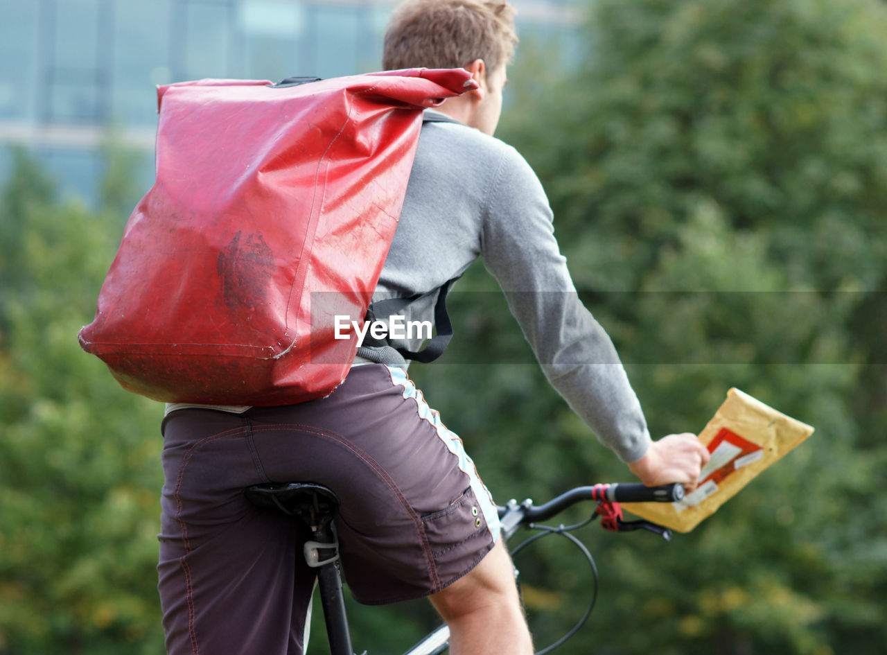 Male bike courier messenger on bicycle delivering a parcel 
