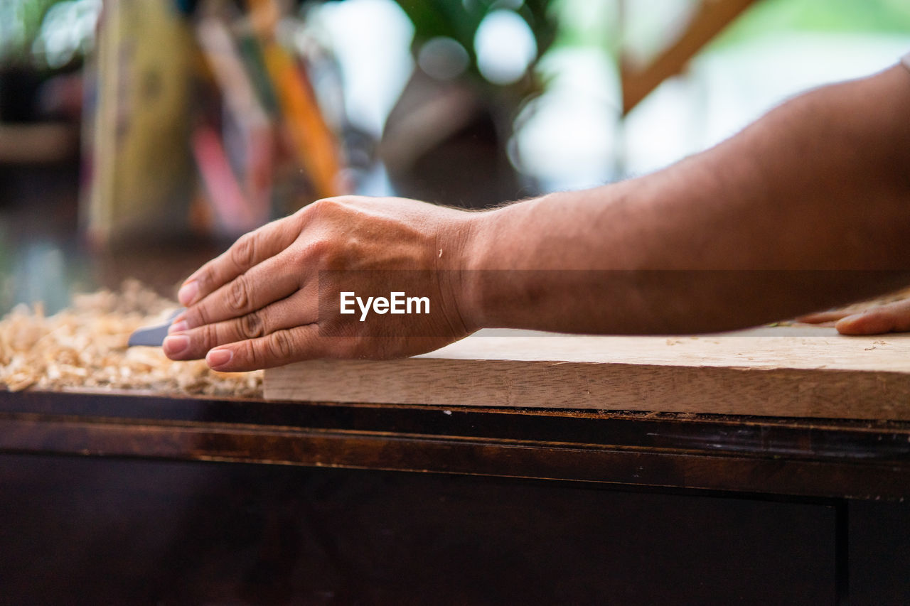 Close-up of man woodworking on table