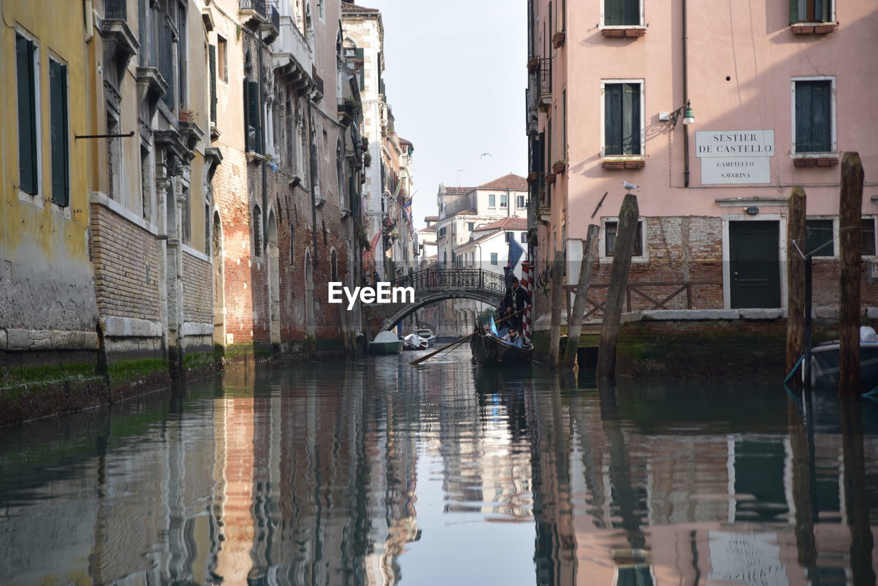 Canal by buildings in city