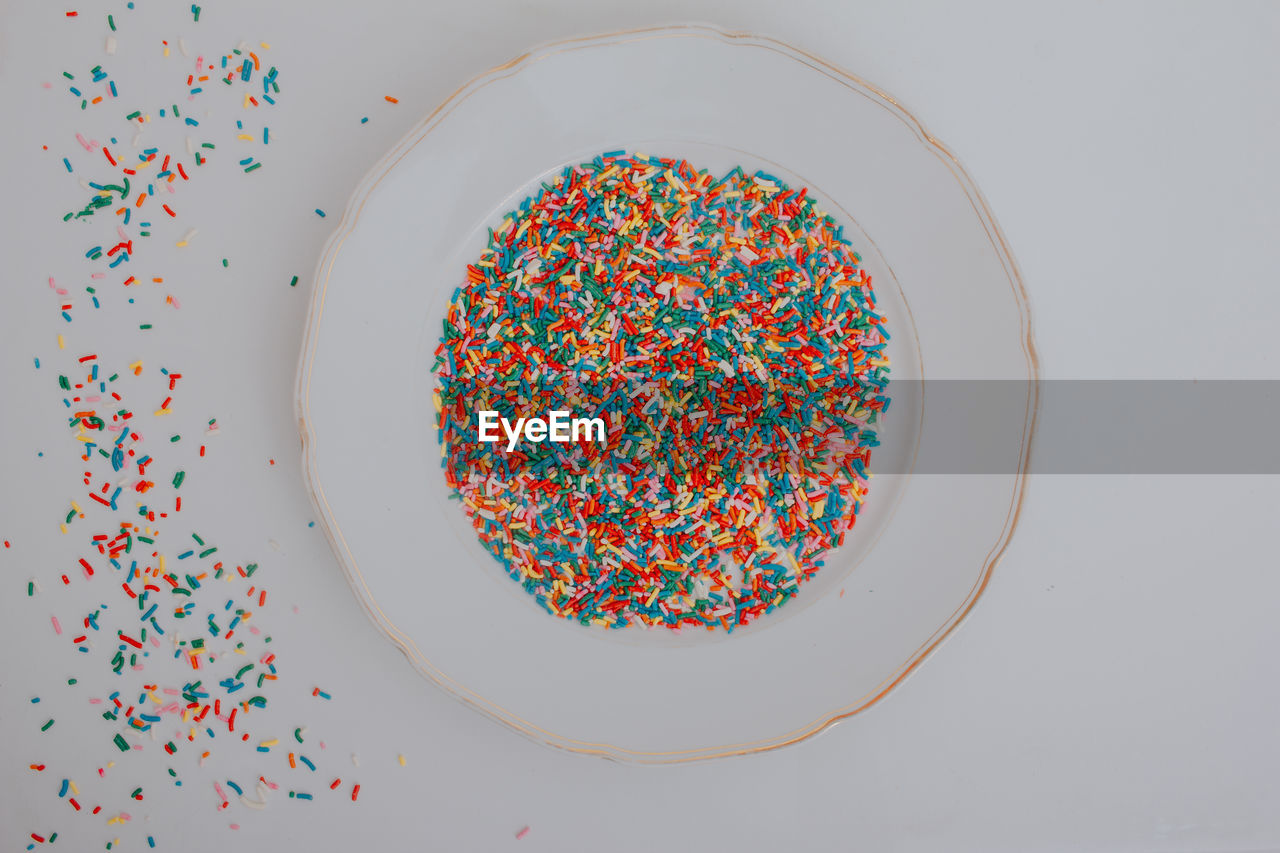 Hands holding plate full of colorful confetti