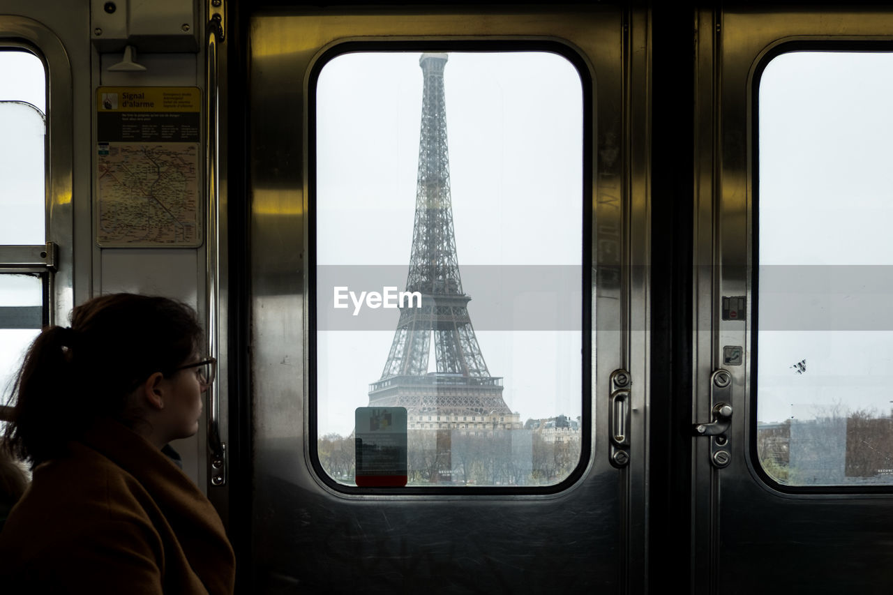 Woman looking at eiffel tower through train window