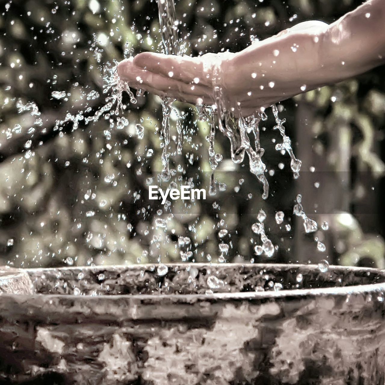 Close-up of water splashing on hand