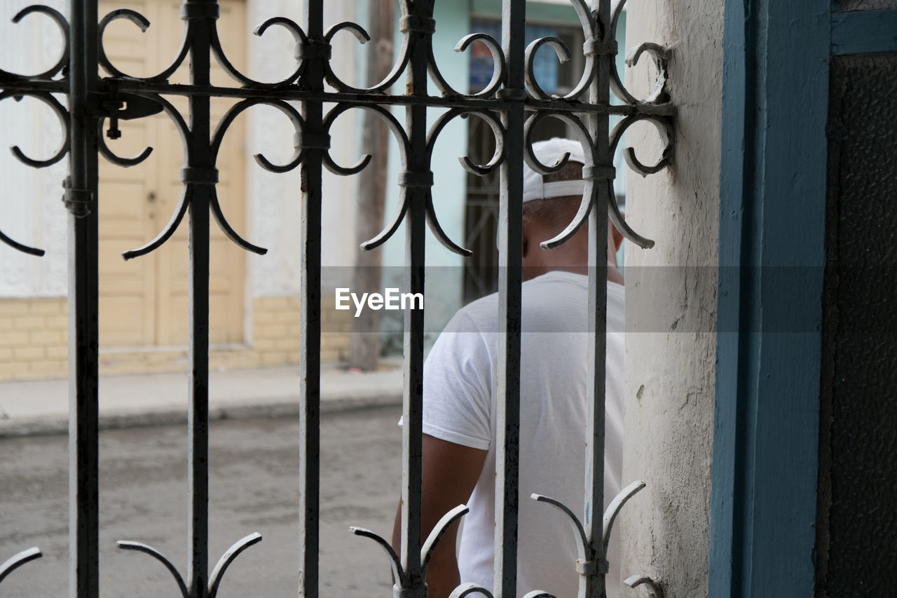 MIDSECTION OF MAN STANDING BY WINDOW