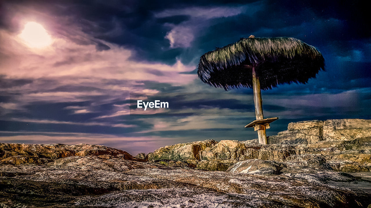 LOW ANGLE VIEW OF ROCKS AGAINST SUNSET SKY