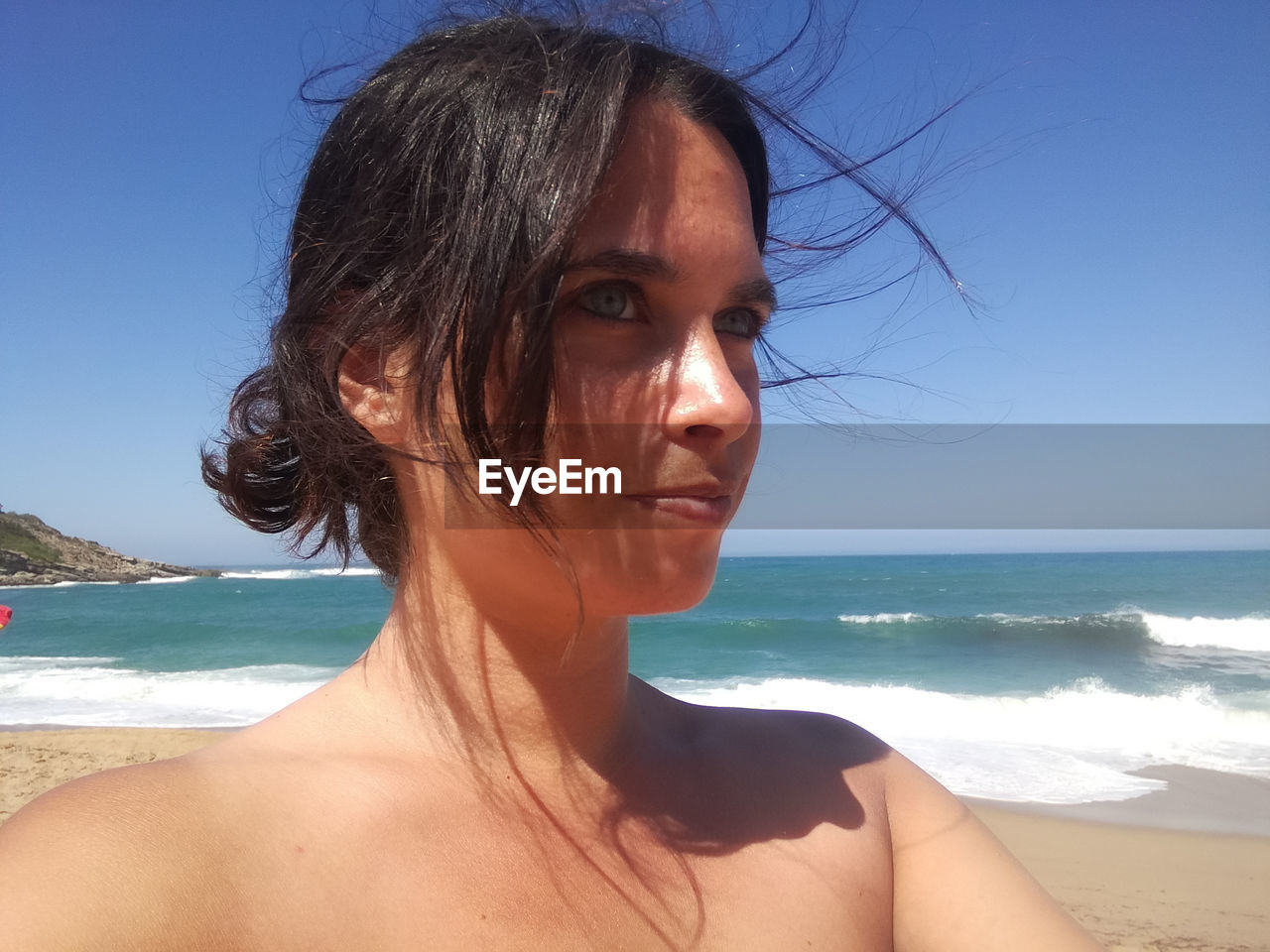 beach, sea, water, land, one person, adult, portrait, sky, women, nature, holiday, vacation, trip, headshot, sand, young adult, sunlight, hairstyle, horizon over water, female, leisure activity, horizon, clear sky, beauty in nature, brown hair, summer, looking at camera, day, blue, sunny, person, emotion, lifestyles, wave, relaxation, sun tanning, smiling, photo shoot, outdoors, motion, ocean, human face, clothing, swimwear, bikini, long hair, travel, looking, happiness, water sports, human hair, travel destinations, tranquility, surfing, sports, scenics - nature, front view
