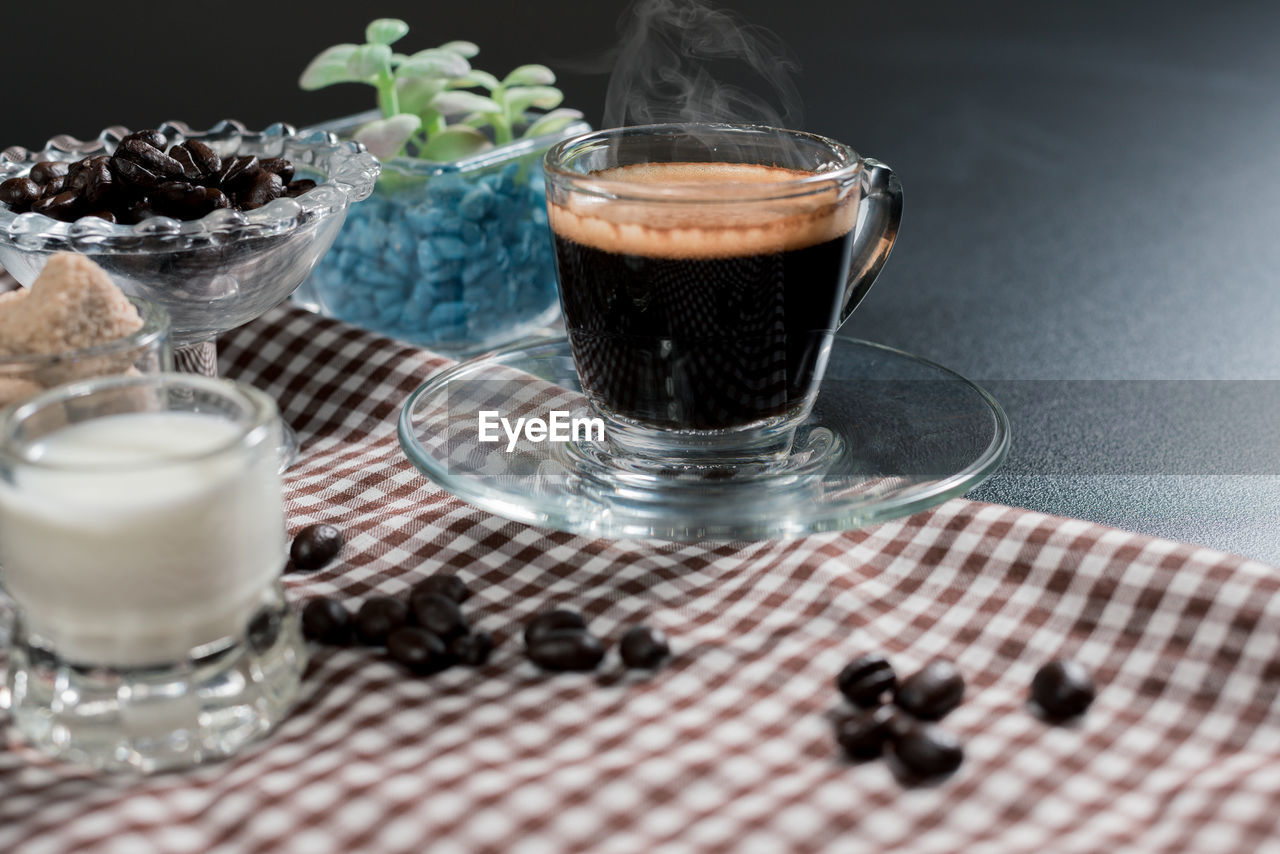 CLOSE-UP OF COFFEE WITH GLASS OF TABLE