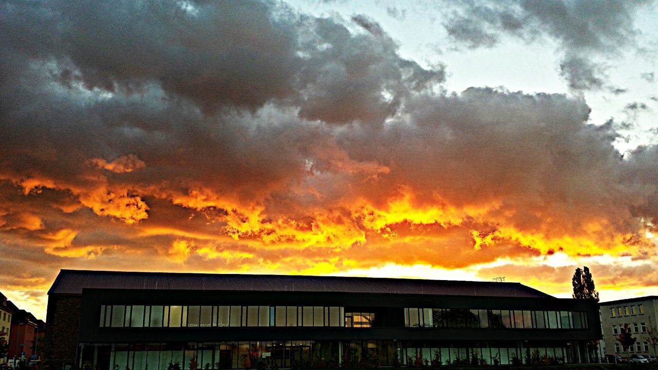 LOW ANGLE VIEW OF BUILDINGS AGAINST DRAMATIC SKY