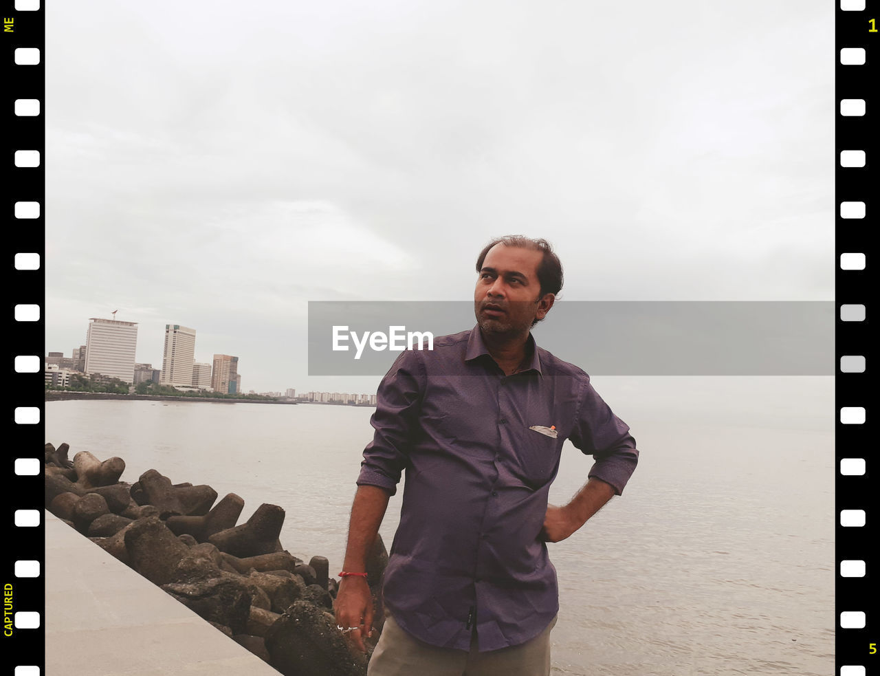 PORTRAIT OF MAN STANDING AGAINST SKY