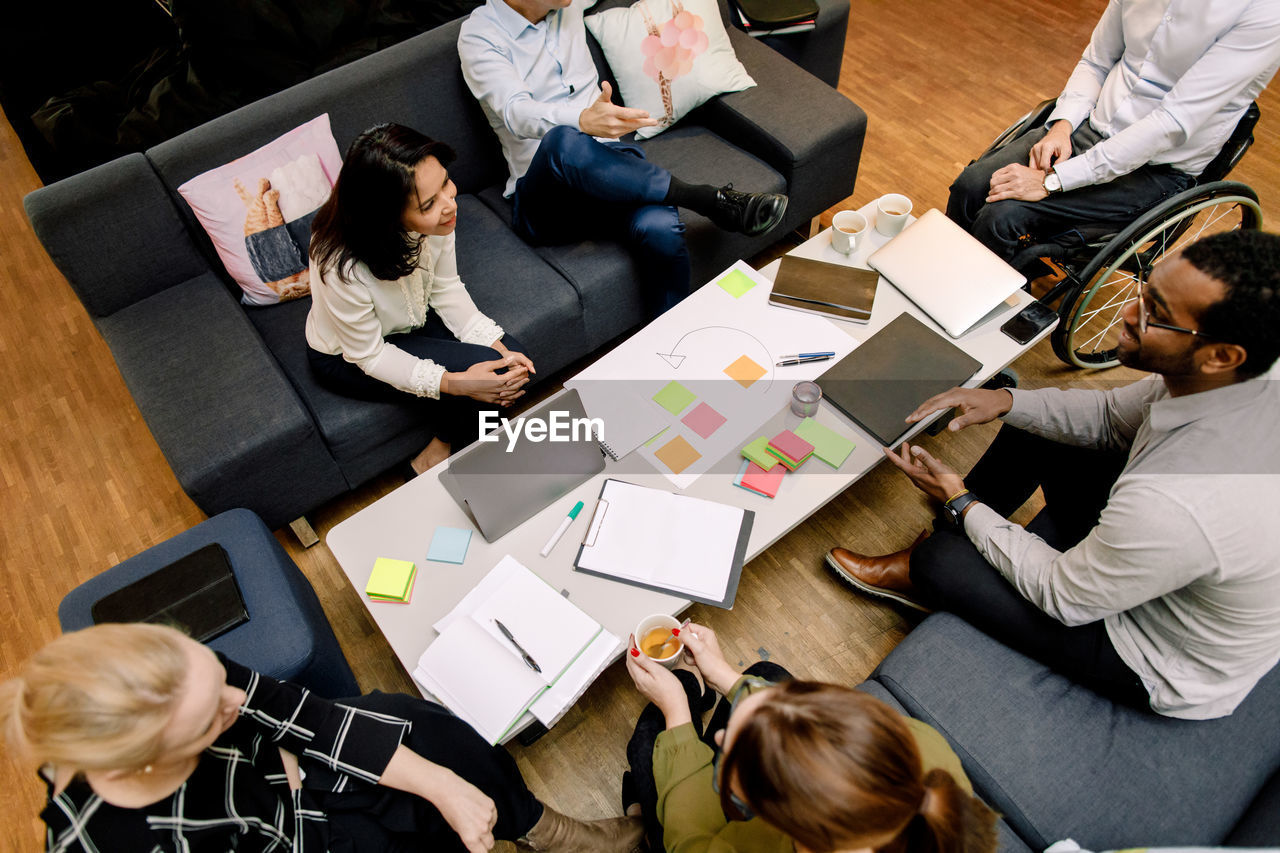 High angle view of sales managers talking during meeting at work place