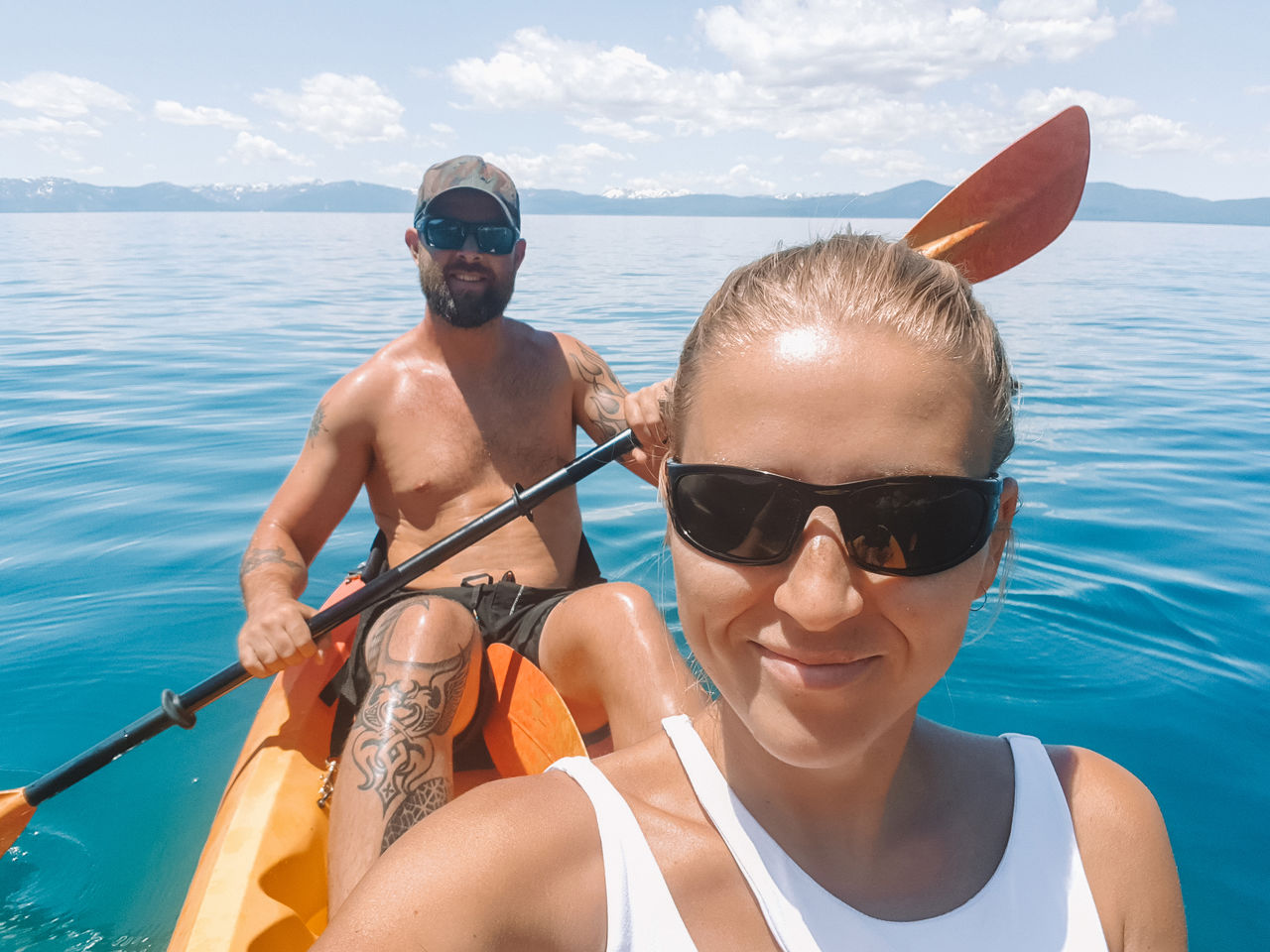 Portrait of smiling couple in boat on sea against sky