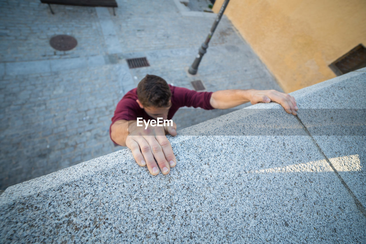 HIGH ANGLE VIEW OF MAN WITH TATTOO ON FLOOR IN BACKGROUND