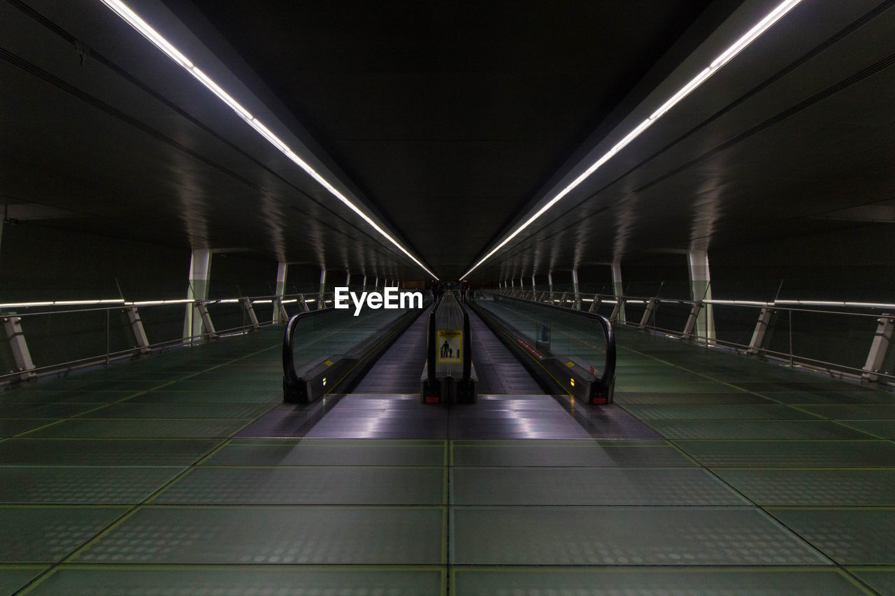 Illuminated moving walkway at subway station at night