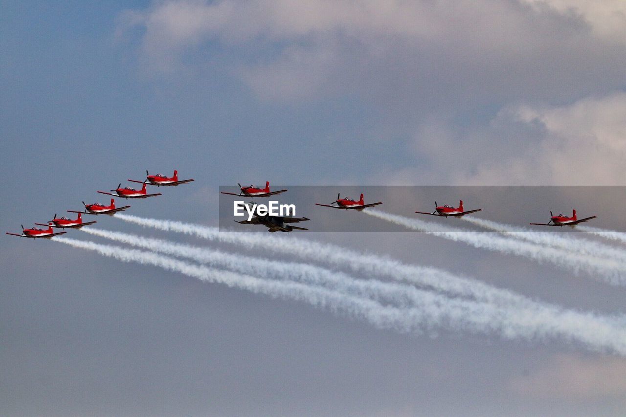 Low angle view of fighter planes flying against sky