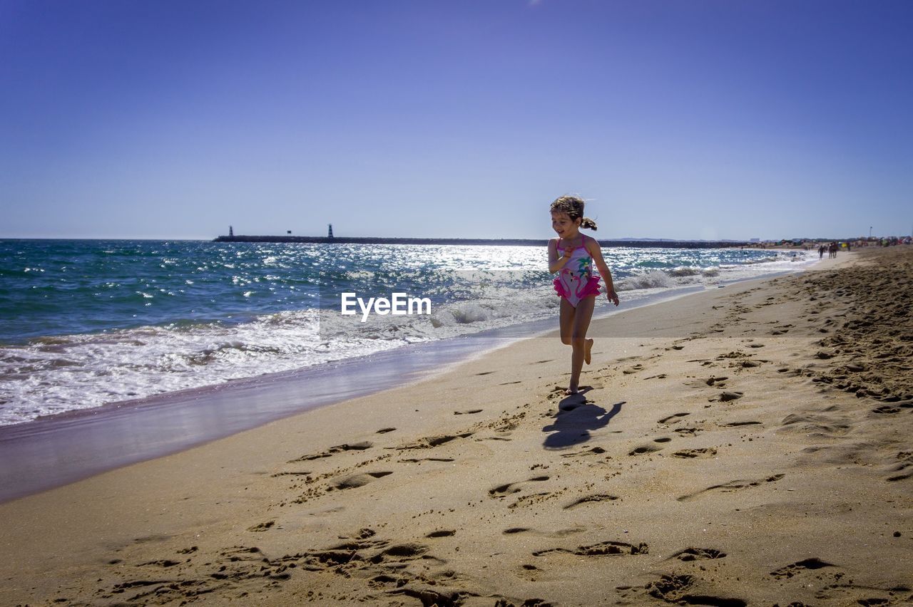 Full length of woman on beach against clear sky