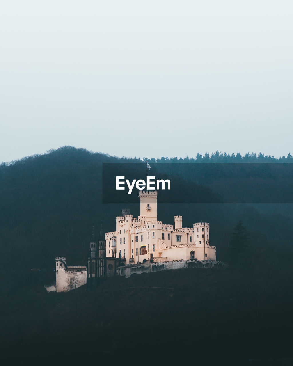 Low angle view of castle on mountain against clear sky