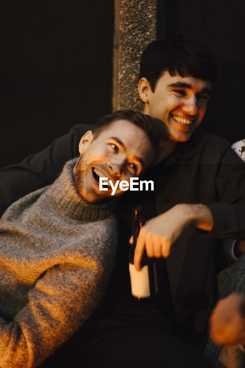 Smiling male friends looking away at balcony