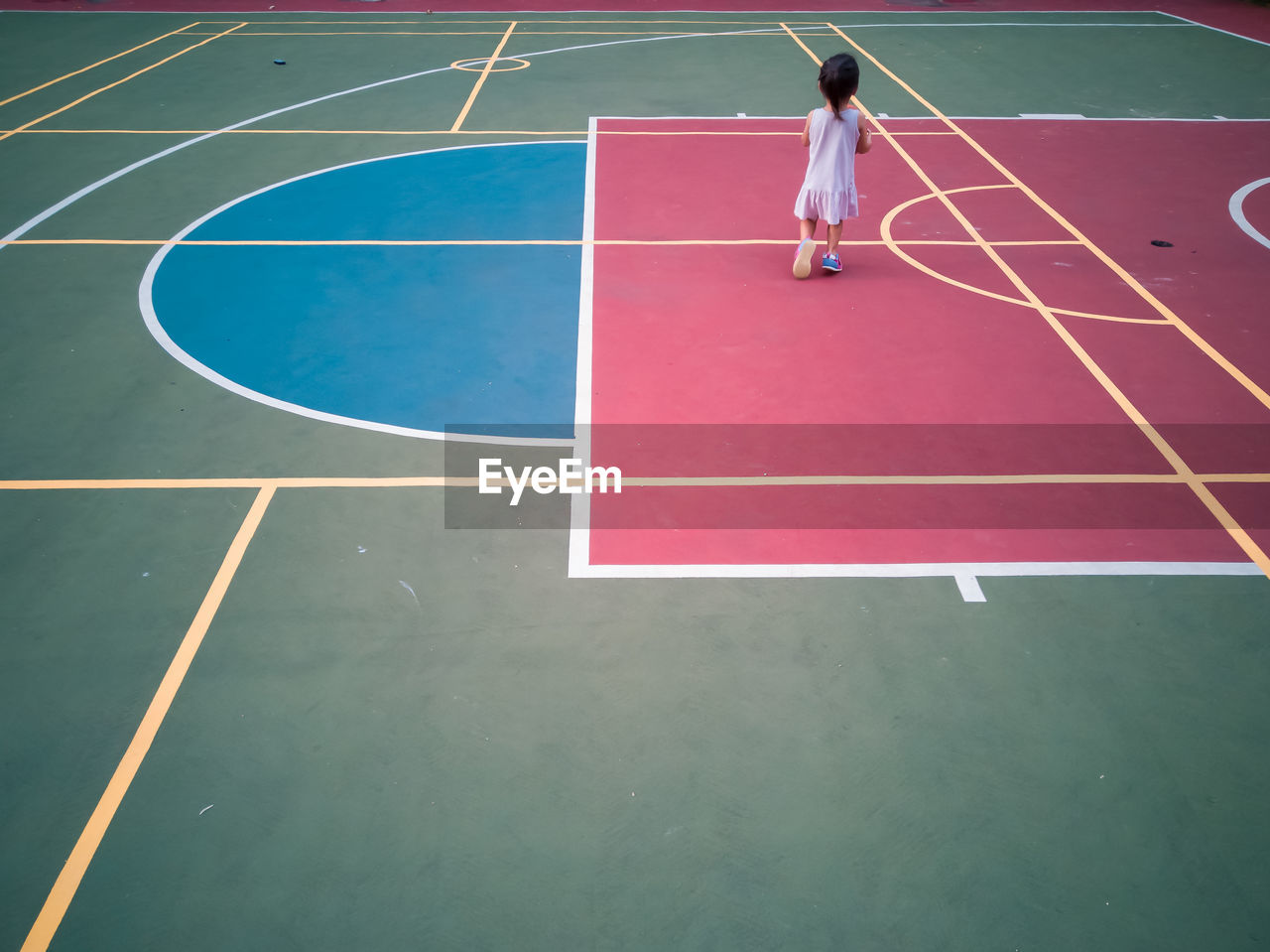Full length of girl playing with basketball