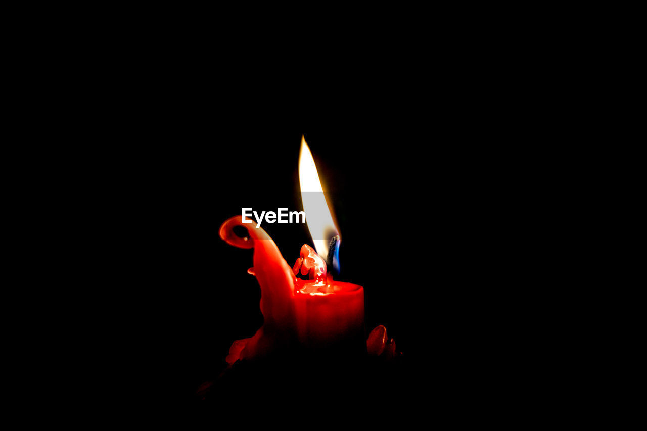 Close-up of lit candle in dark room