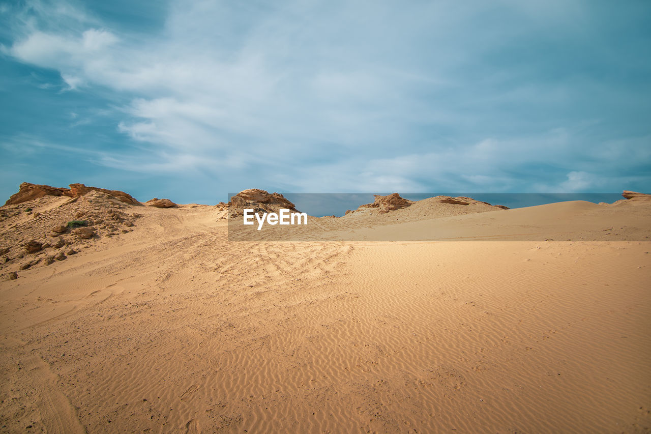 Sand dunes in desert against sky