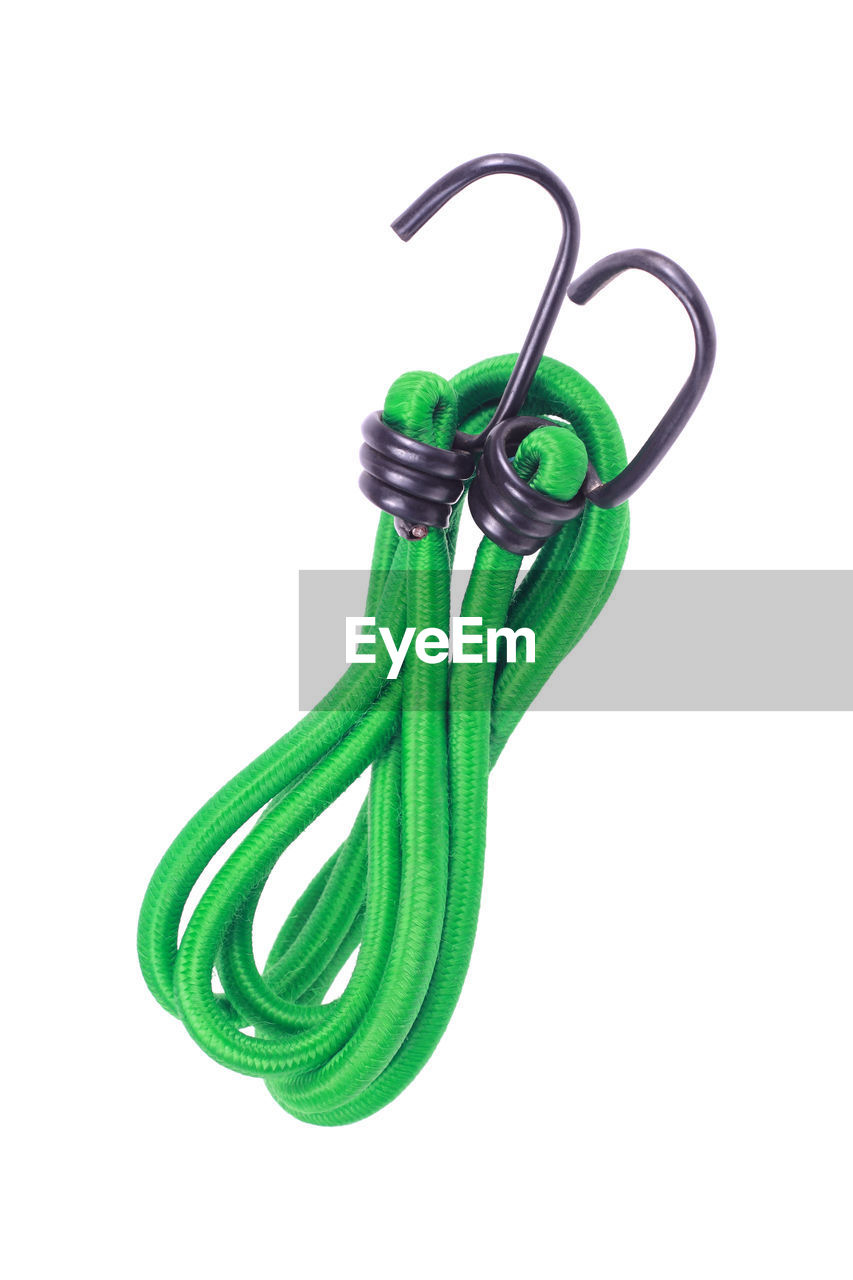 CLOSE-UP OF ROPE TIED UP ON GREEN BACKGROUND